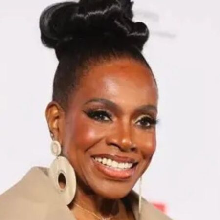 Close-up of Sheryl Lee Ralph smiling at the DIVAs Simply Singing! health awareness event in Los Angeles. She is styled with a sleek high bun and statement earrings, representing her decades of advocacy for HIV/AIDS prevention.