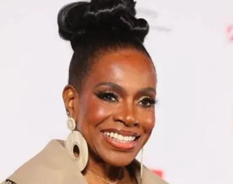 Close-up of Sheryl Lee Ralph smiling at the DIVAs Simply Singing! health awareness event in Los Angeles. She is styled with a sleek high bun and statement earrings, representing her decades of advocacy for HIV/AIDS prevention.