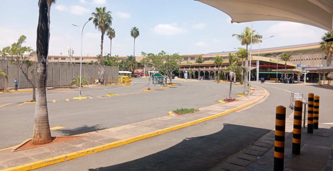 Palm-lined access road and terminal buildings at Jomo Kenyatta International Airport in Nairobi.