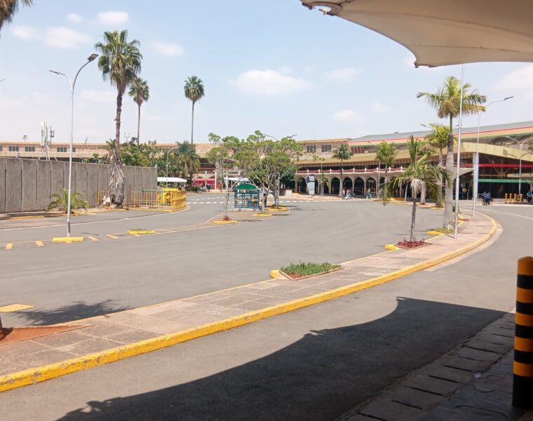 Palm-lined access road and terminal buildings at Jomo Kenyatta International Airport in Nairobi.