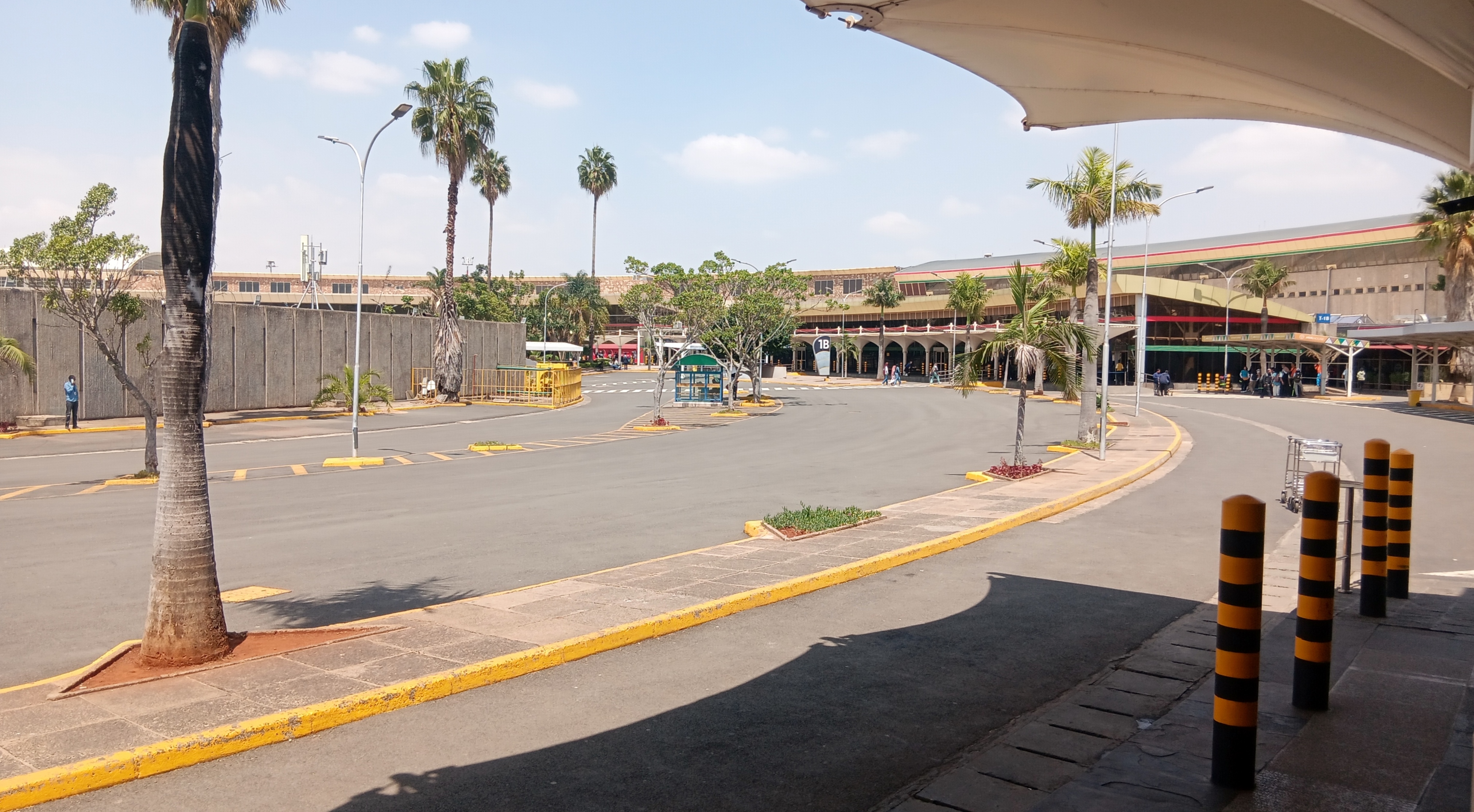 Palm-lined access road and terminal buildings at Jomo Kenyatta International Airport in Nairobi.